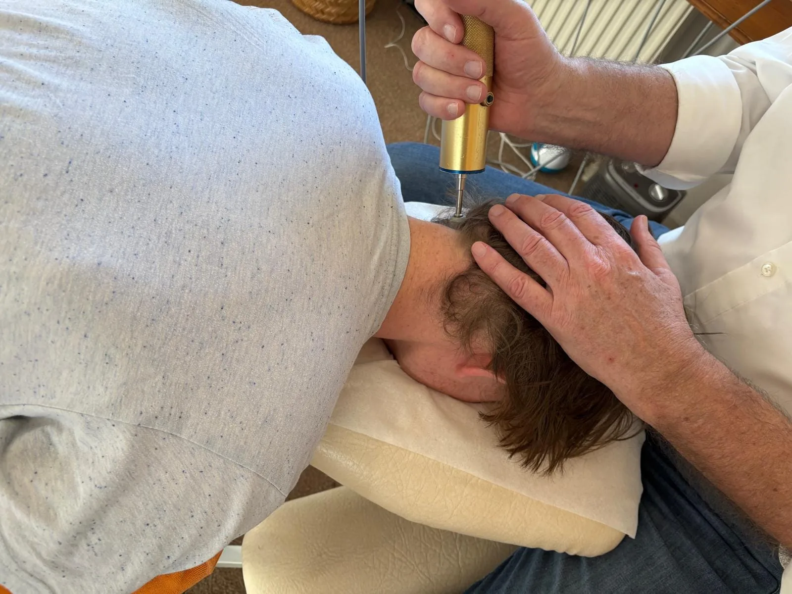 Close-up of the atlas correction device applied below the skull during treatment